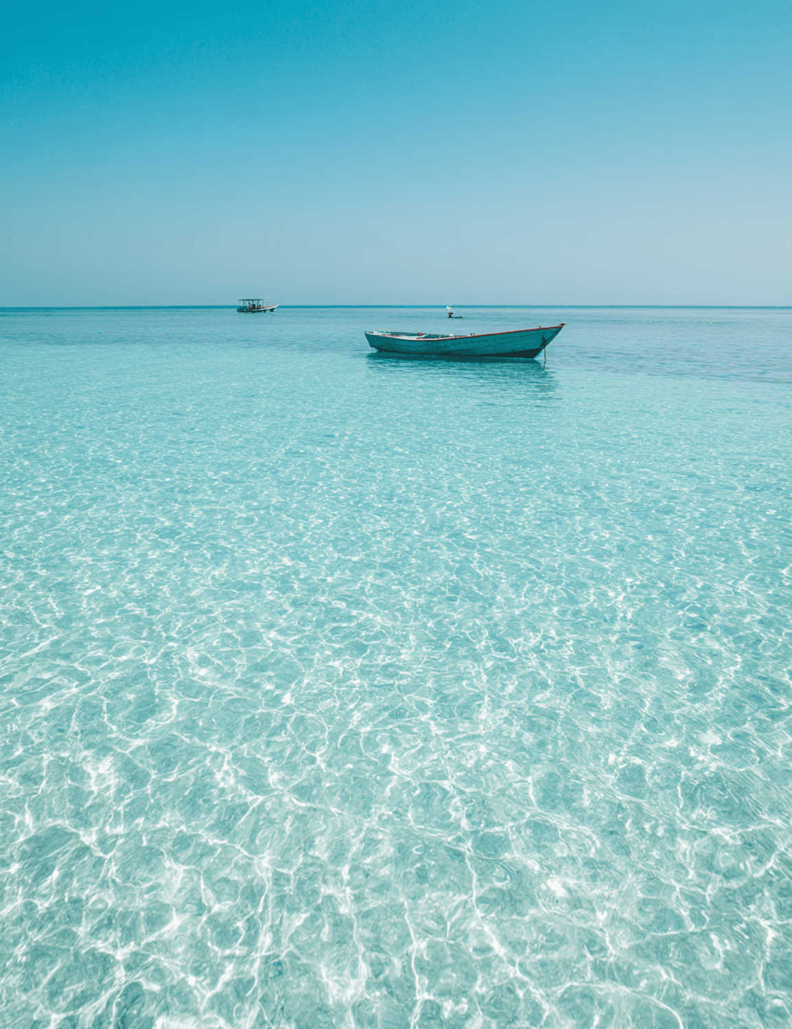 A small wooden boat on clear turquoise water